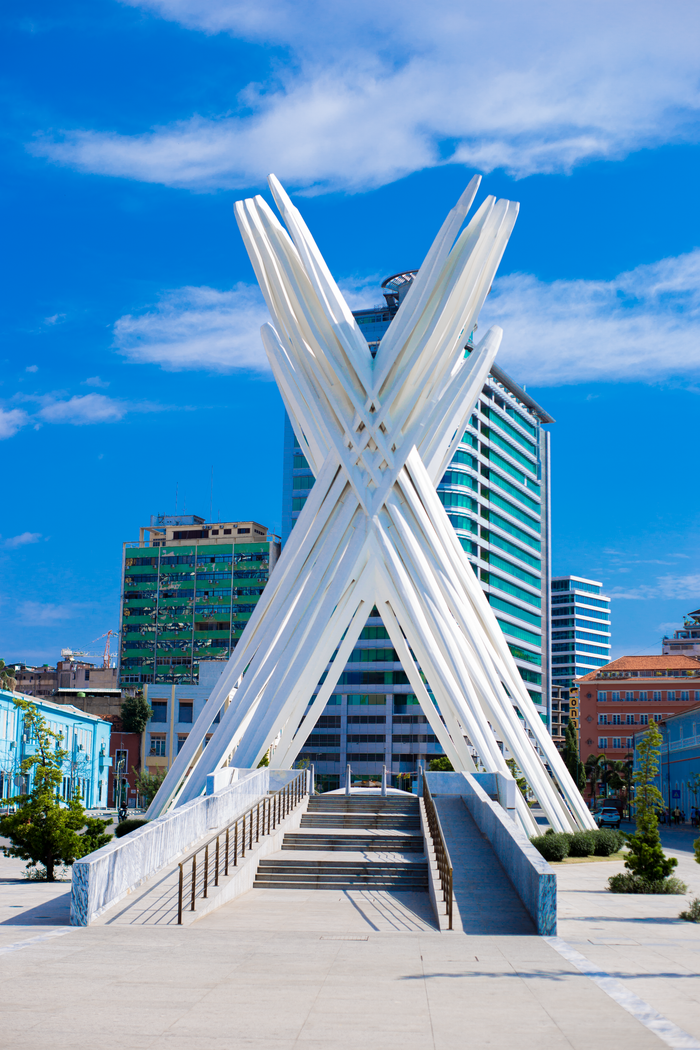Modern architectural sculpture against Luanda's skyline with a clear blue sky.