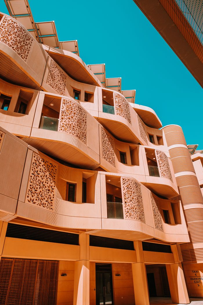 Modern architectural facade with intricate designs in UAE under clear blue sky.