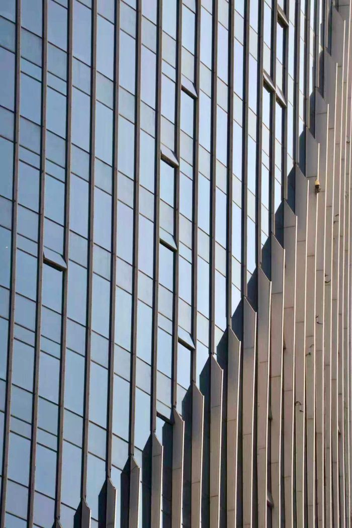 Close-up of a modern skyscraper facade featuring vertical lines and geometric shapes.