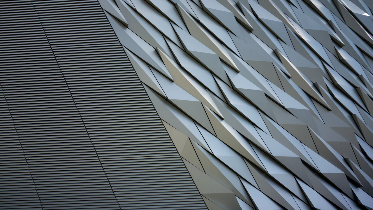 Close-up of a modern architectural facade featuring a striking geometric pattern and textured surfaces.
